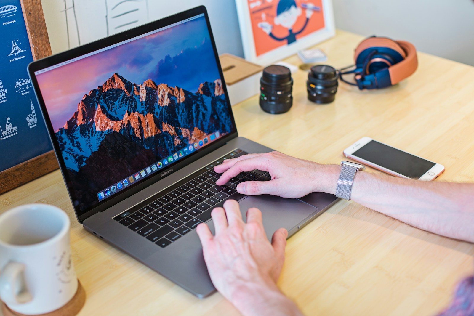 MacBook Pro allumé à côté d'une tasse en céramique blanche