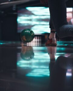 personne en pantalon noir et chaussures marron assise sur une boule de verre