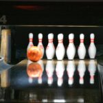 une boule de bowling va frapper les quilles