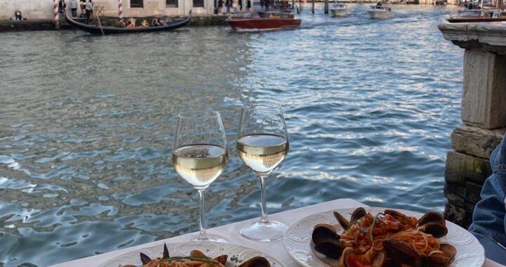 Découvrez un dîner de luxe au bord des canaux de Venise avec des fruits de mer et du vin blanc.