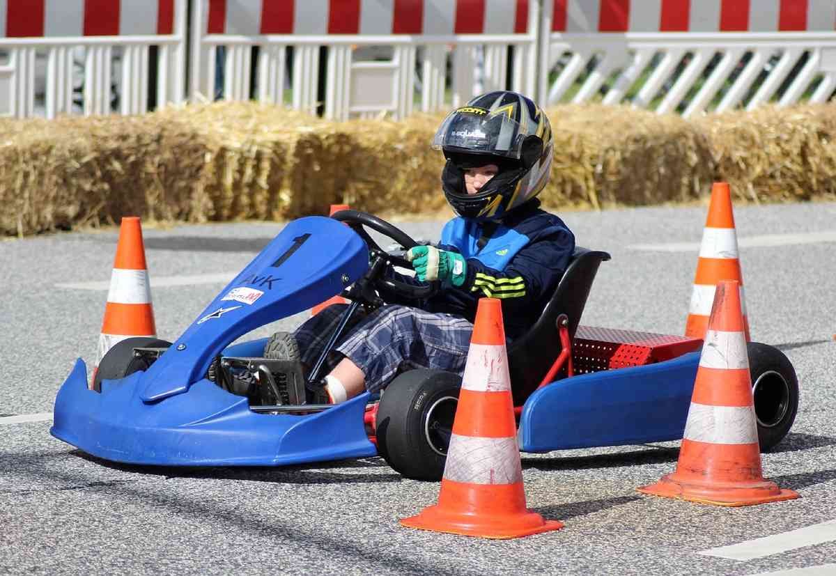 Enfant pilotant un kart bleu sur une piste de course miniature