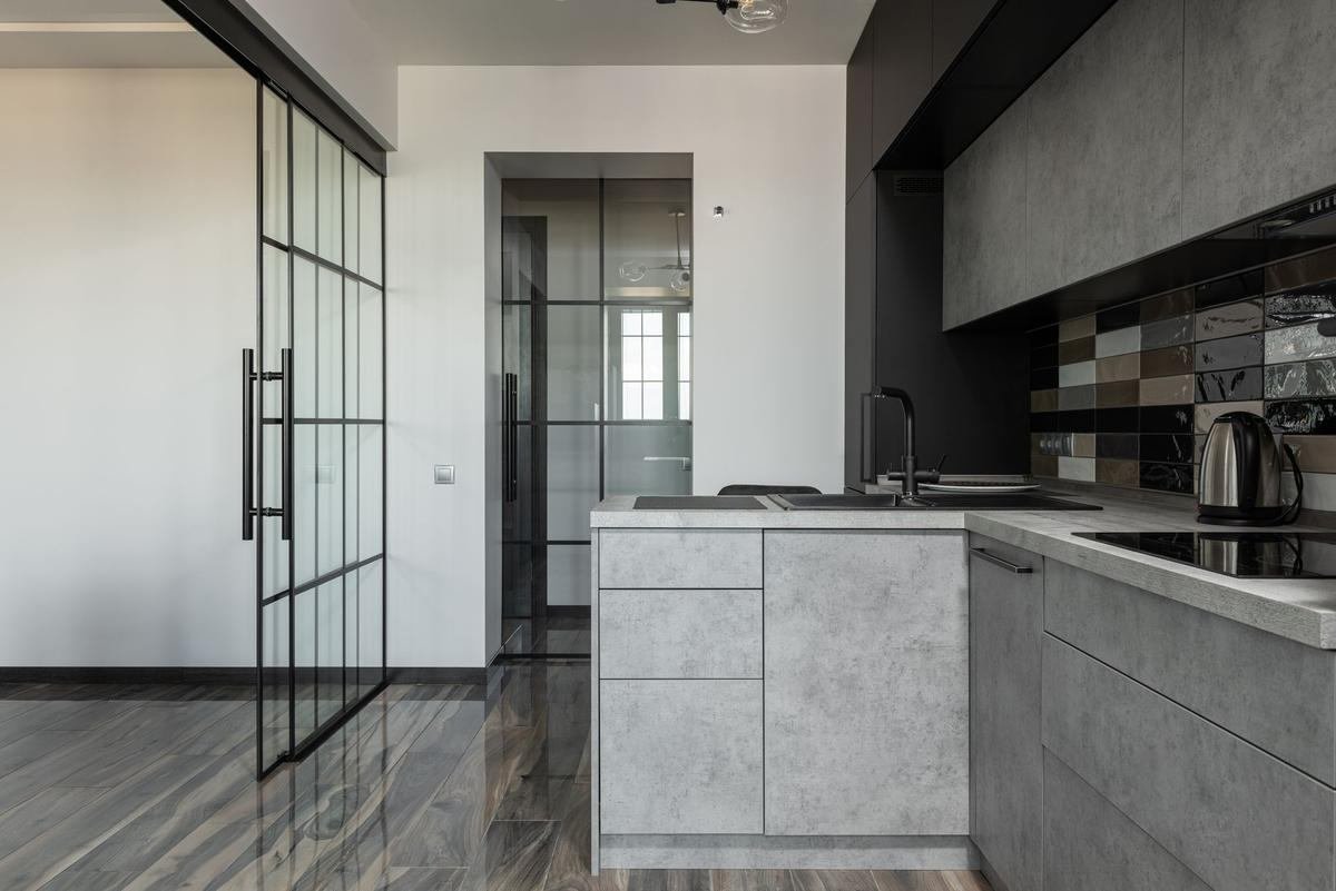 Cuisine moderne avec îlot central et porte coulissante vitrée Cuisine moderne avec îlot central et porte coulissante vitrée