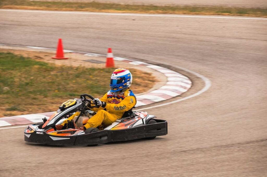 Un coureur en combinaison jaune pilote un kart sur virage de circuit