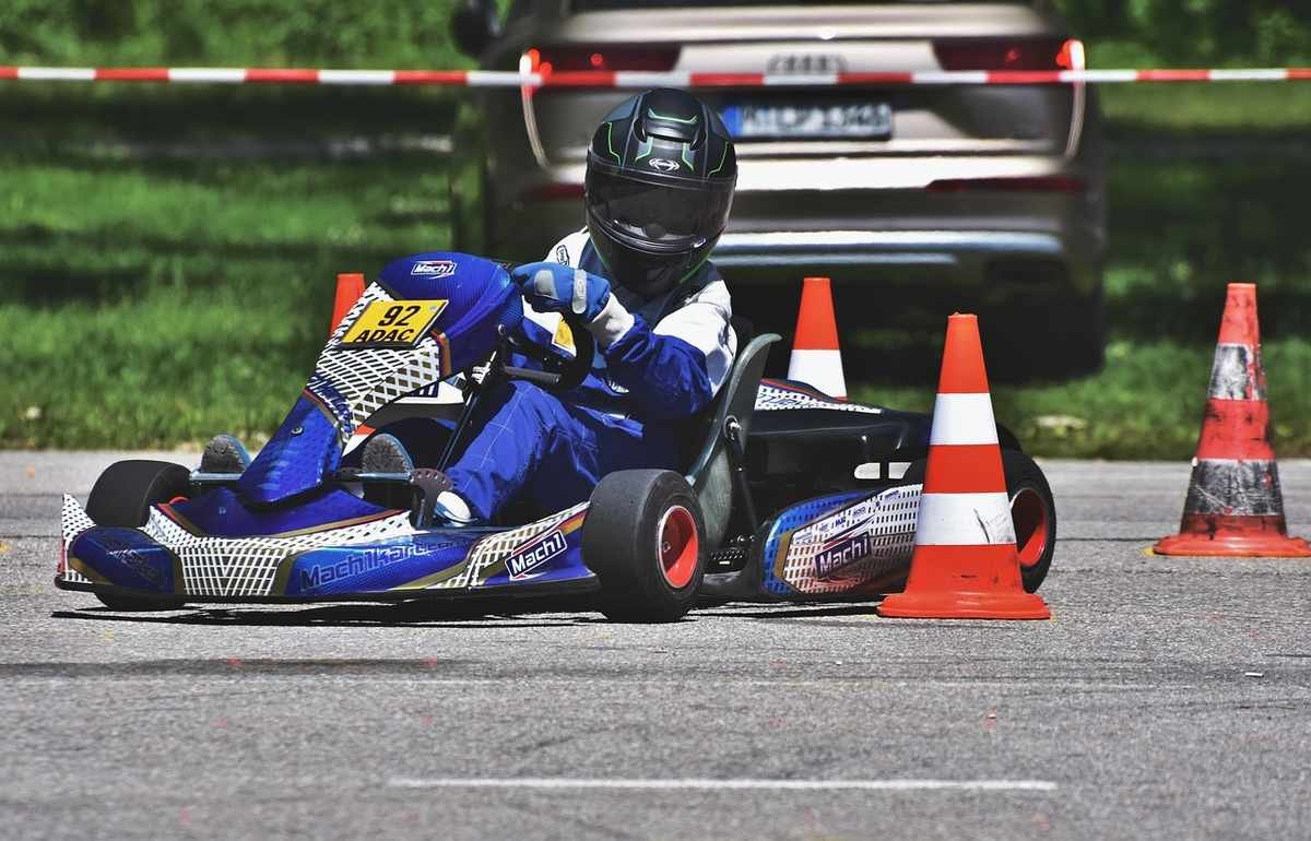Un conducteur en kart bleu évite des cônes sur une piste d'essai Un conducteur en kart bleu évite des cônes sur une piste d'essai