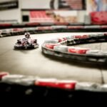 Un karting intérieur avec un pilote en kart sur virage
