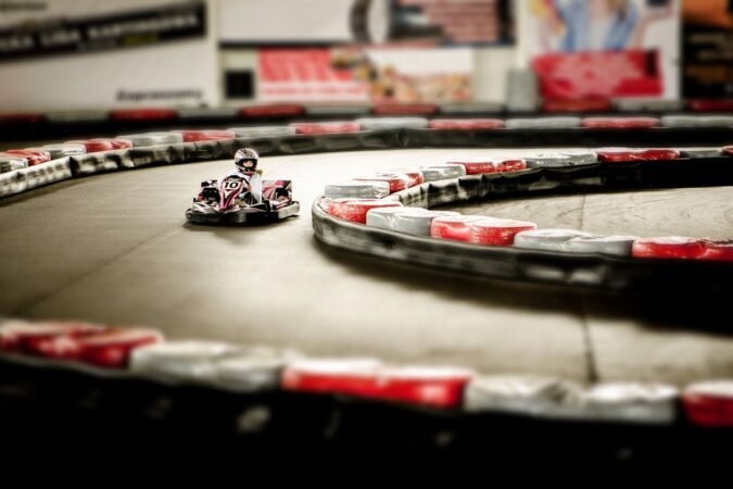Un karting intérieur avec un pilote en kart sur virage