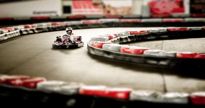 Un karting intérieur avec un pilote en kart sur virage