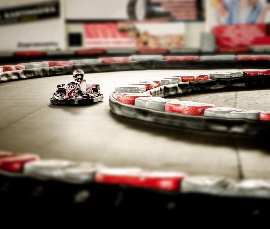 Un karting intérieur avec un pilote en kart sur virage