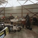 Deux personnes travaillent sur des kartings dans un entrepôt